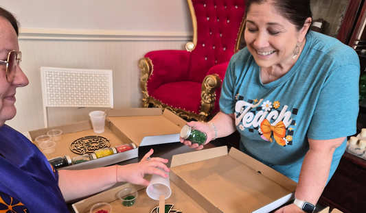Artisan Deborah Ramirez providing hands-on instruction to a student during a crushed glass resin art workshop at The Shoppes Off Trade in Greer, SC.